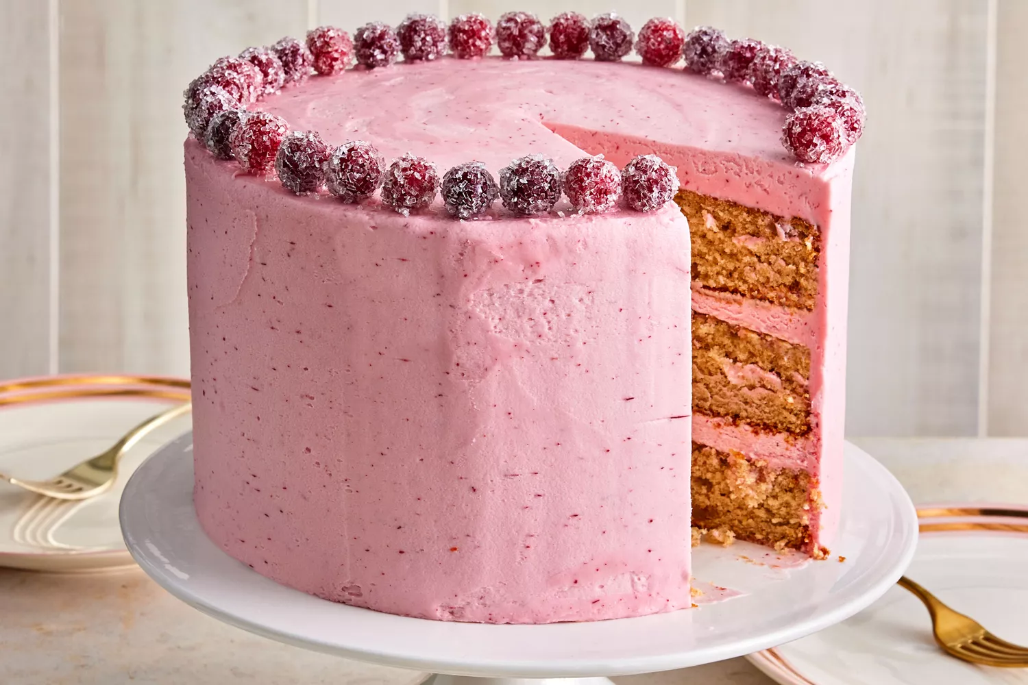 Gingerbread cake with cranberry-vanilla frosting on white cake stand