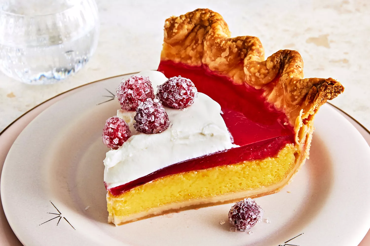 Orange chess pie with cranberry gelÃ©e on white plate