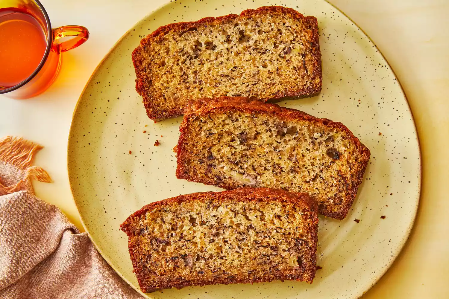 Southern Living One Bowl Banana Bread sliced on a plate to serve with a cup of tea